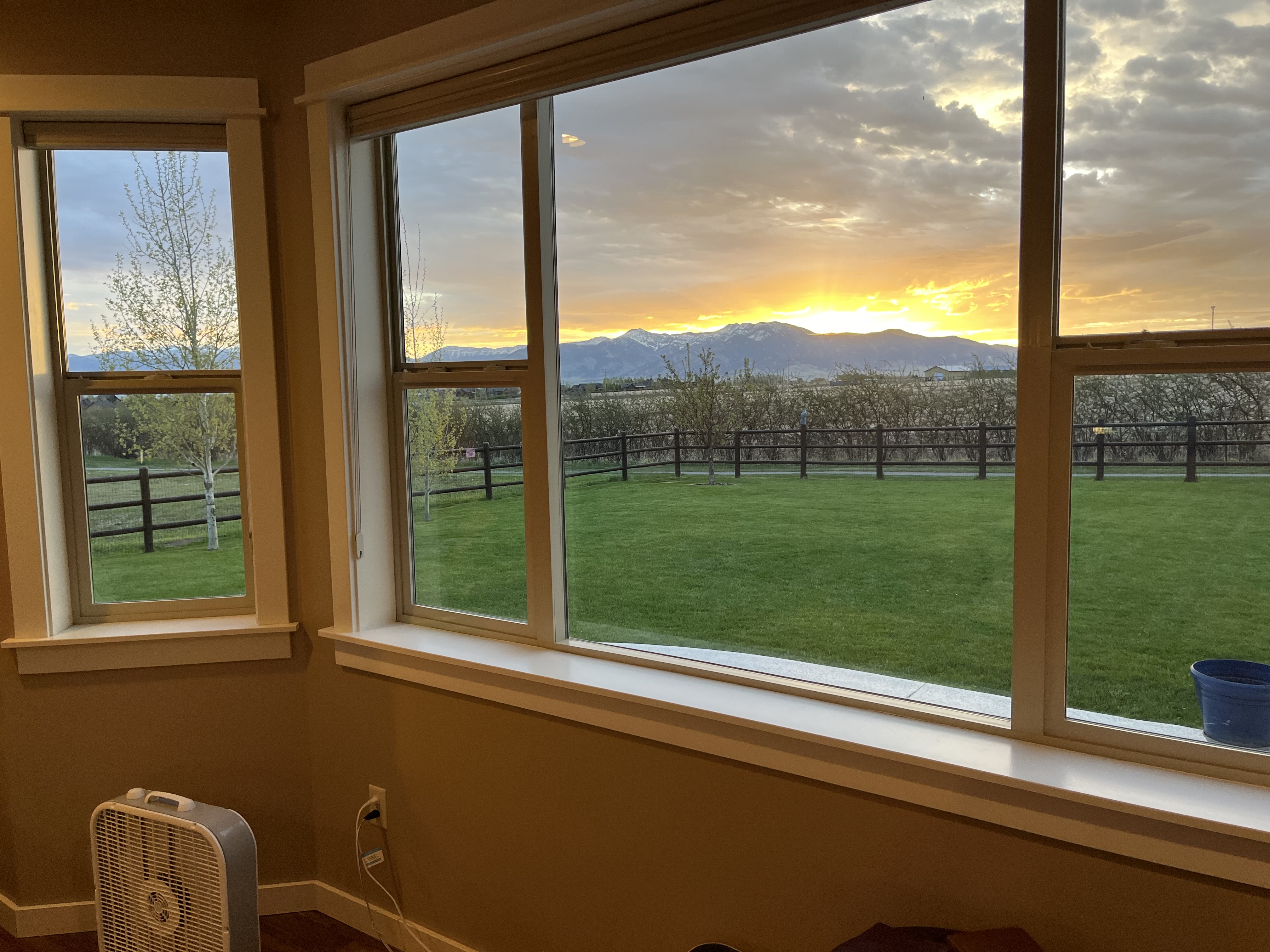 View of a brown fence and the Bozeman mountains at sunset